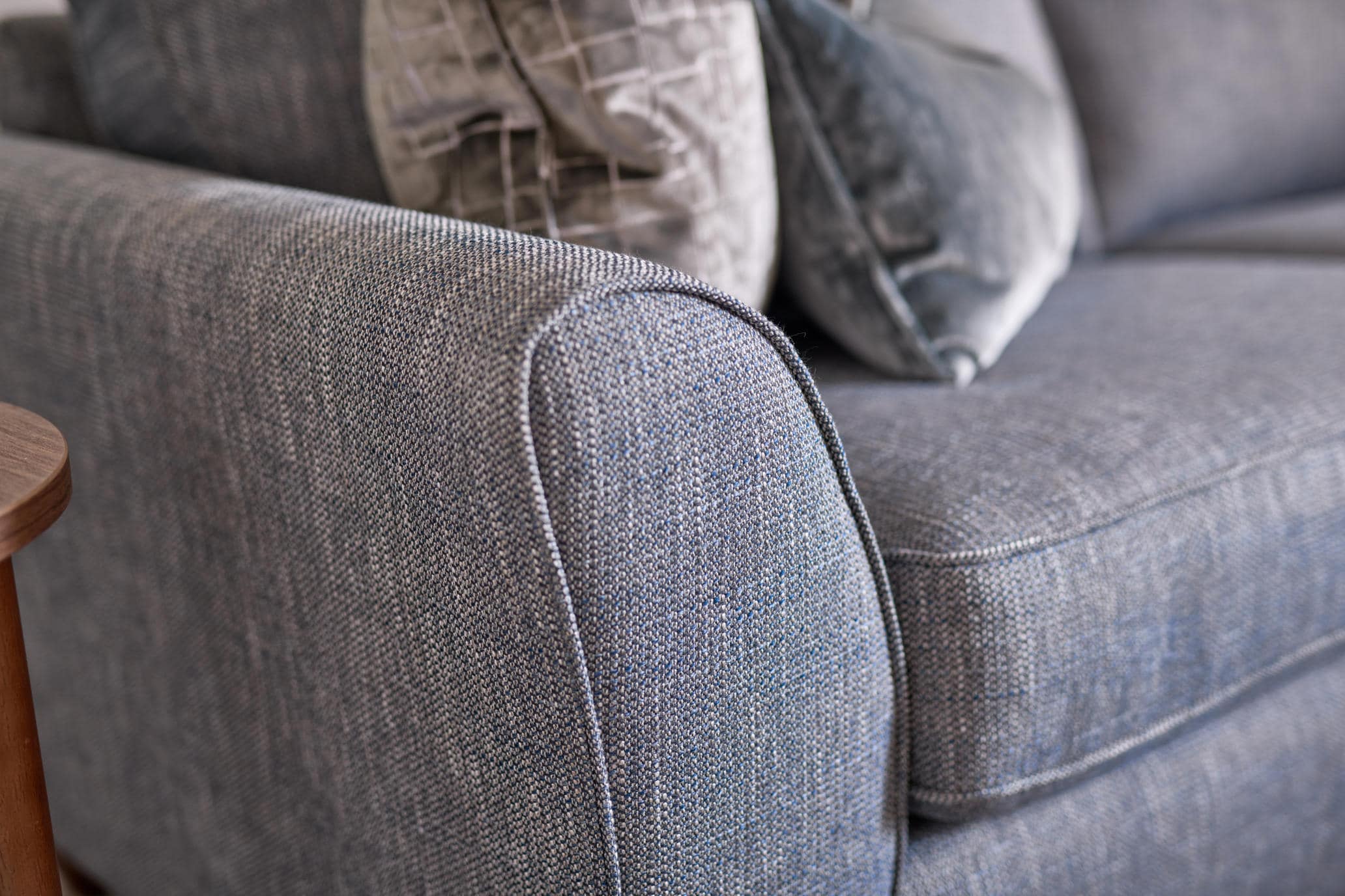 Close-up of the Oddicum sofa curved arm, piped edges and blue-grey woven upholstery.